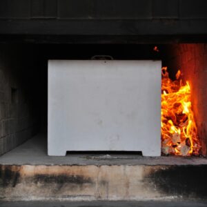 A cremation container is utilized to transport the body into the oven